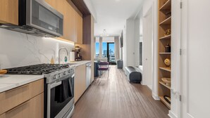 A modern kitchen with a built-in microwave, stove, and oven. - 22nd floor Luxury Midtown ATL haven—2mi from FIFA (Atlanta)