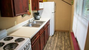 A compact kitchen with a stove, sink, and refrigerator. - Riverfront Cabins  and  Vacation Homes (Rio Frio)