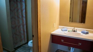 A bathroom with a sink, mirror, and towel rack. - Riverfront Cabins  and  Vacation Homes (Rio Frio)