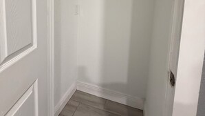 A narrow hallway with white walls and a wooden floor. - Private 1BR Suite, Free Parking, Near Downtown & Airport (Tampa)