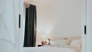 Un dormitorio con cama, mesita de noche, lámpara y candelabro.
