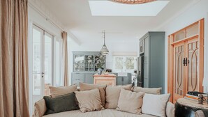 Un dormitorio con una cama, una cocina al fondo y vistas por la ventana.