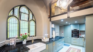 A kitchen with a double sink, a large window with stained glass, and a built-in oven. - Grade C Church in Cannich, Sleeps 2 w/ Parking (Beauly)