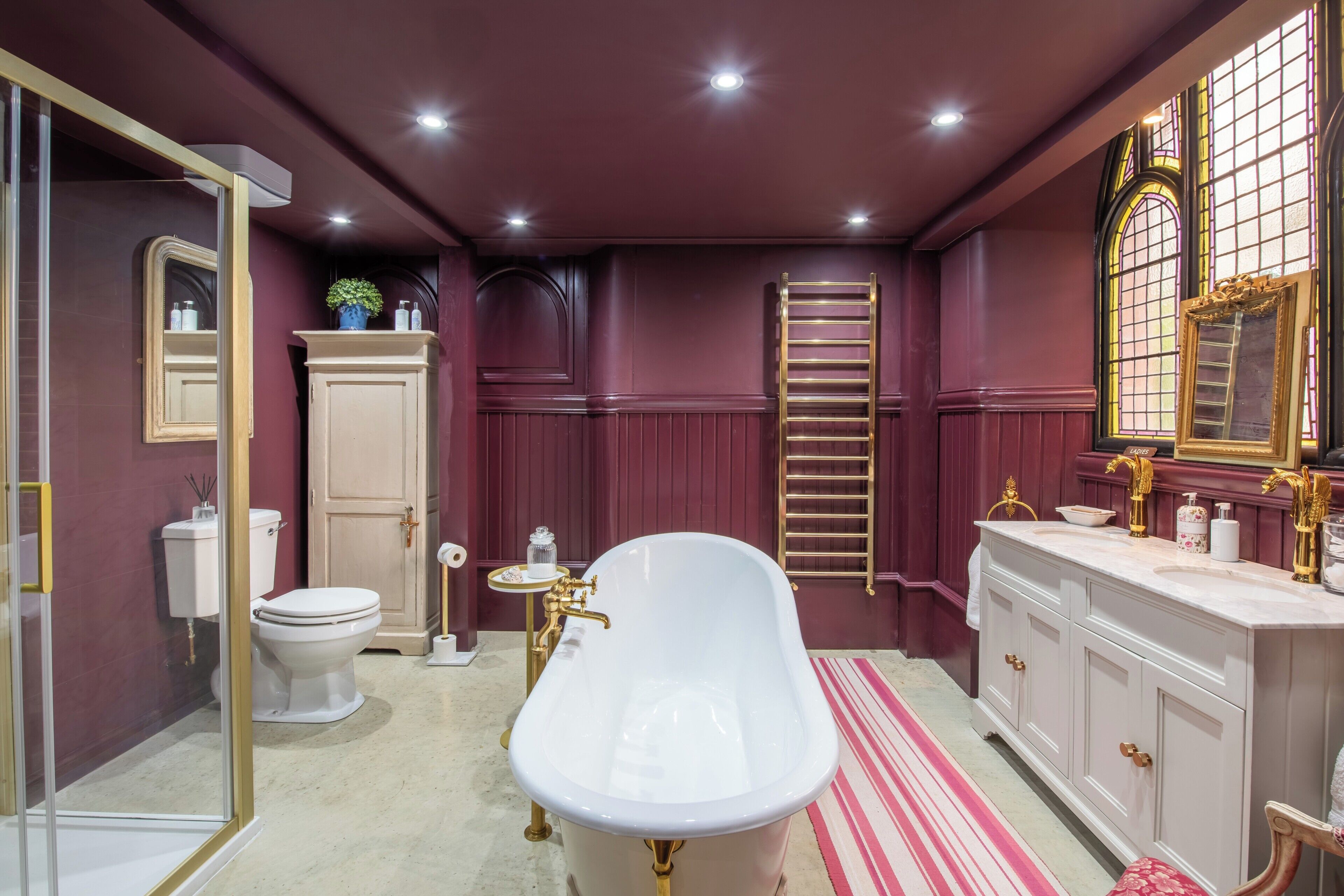 A bathroom with a freestanding bathtub, a vanity with a mirror, a toilet, and a shower area.