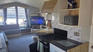 Um espaço compacto com cozinha, área de estar e televisão.