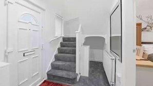 A staircase leading to a landing with a white door and a red carpet. - Nottingham Home 4 Bedrooms sleeps 7 city hospital (Nottingham)