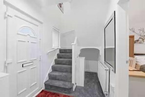 A staircase leading to a landing with a white door and a red carpet. - Nottingham Home 4 Bedrooms sleeps 7 city hospital (Nottingham)