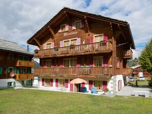 A traditional wooden building with a balcony, a sign reading 'Bendsfern,' and a small outdoor seating area. - Abendstern, (Grächen), by Interhome (Grächen)