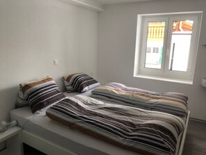 A bedroom with a single bed, a window, and a nightstand. - Abendstern, (Grächen), by Interhome (Grächen)