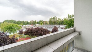 Ein Balkon mit Blick auf eine Wohngegend, mit Häusern und Bäumen.