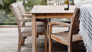 A wooden deck with a table and chairs, a bottle of wine, and a glass. - The Mariner by Experience Metung (Metung)