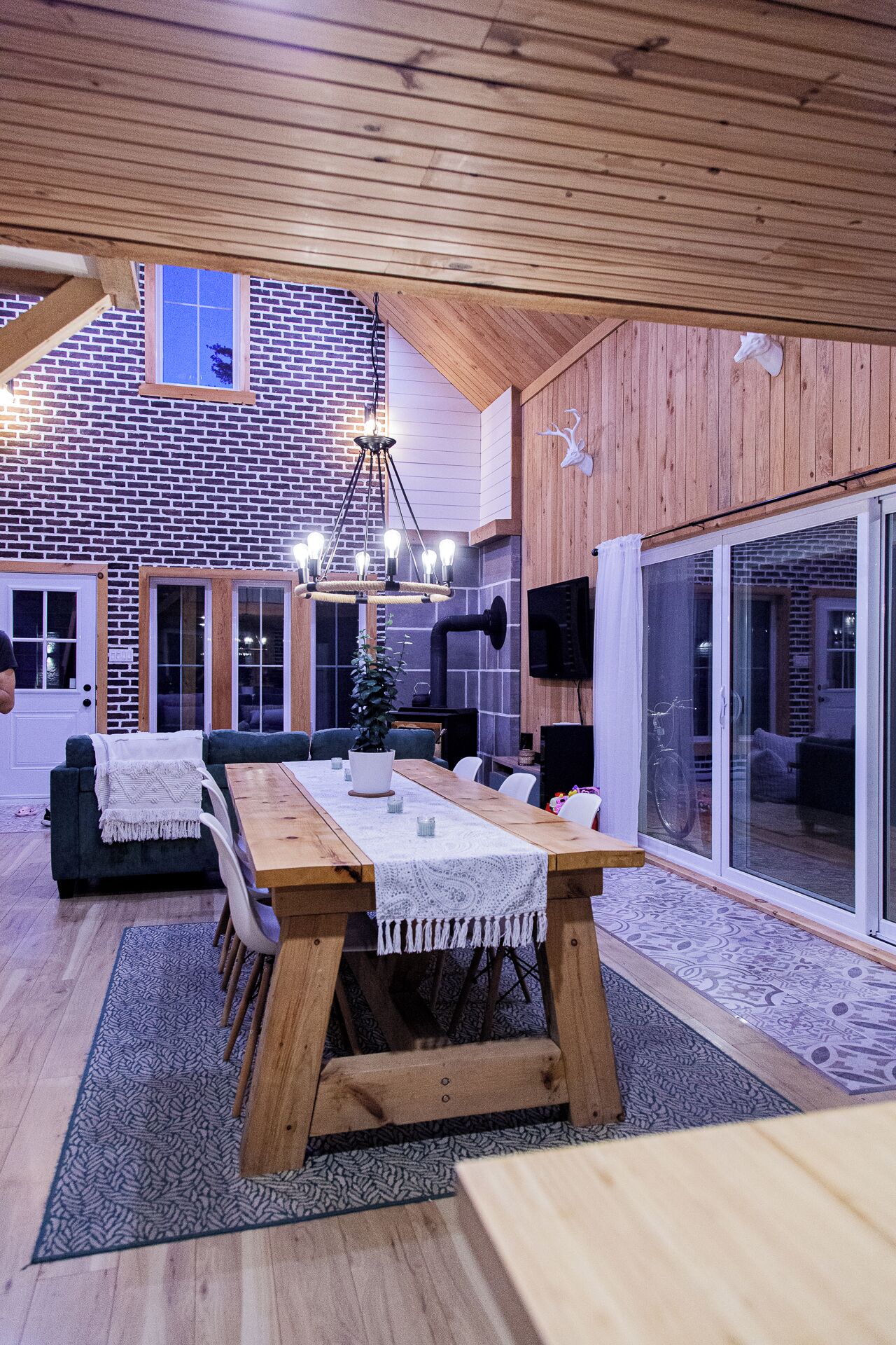 A spacious dining area with a wooden table, chairs, and a chandelier.