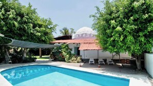 A swimming pool with a white building in the background, surrounded by trees. - Geodesic sanctuary with a heated pool (Chiconcuac)
