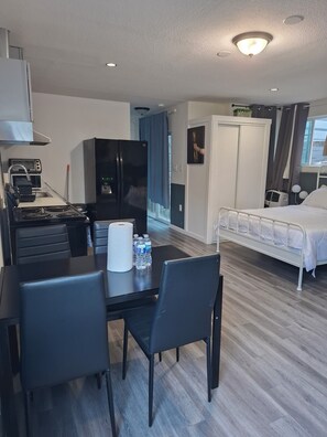 A hotel room with a kitchenette, a bed, a wardrobe, and a bathroom. -  Adorable Queen Bed Oakland Zoo with Private space and cool AC (Oakland)