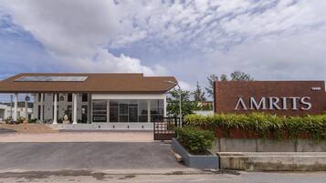Un bâtiment moderne avec une enseigne indiquant « AMRITS » et un bureau de vente.