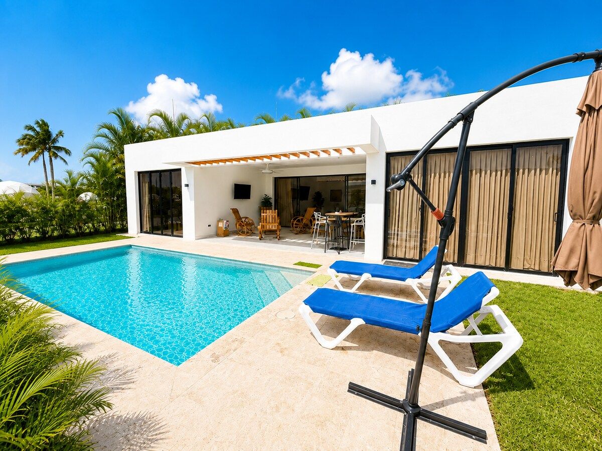 Une maison moderne dotée d’une piscine, d’un espace salon extérieur et d’un patio couvert.
