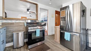 A modern kitchen with a stainless steel refrigerator, a built-in oven, and a gas stove. - Pet-Friendly Getaway Downtown (Hot Springs)
