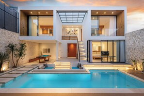 Uma casa moderna de dois andares com piscina, escadaria e área de jantar.