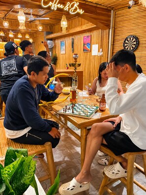 Un intérieur en bois agrémenté d’un jeu d’échecs, d’un narguilé et d’un jeu de fléchettes.