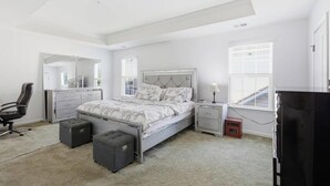 A bedroom with a bed, a desk, a chair, a dresser, and a television. - Spacious 5BR house in tranquil Wash DC community has Sauna, fitness, and more (Washington)