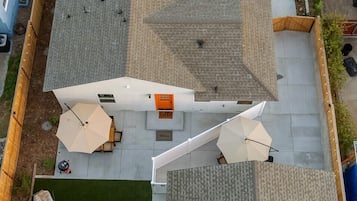 A rooftop with a small airplane, outdoor seating, and a paved area.