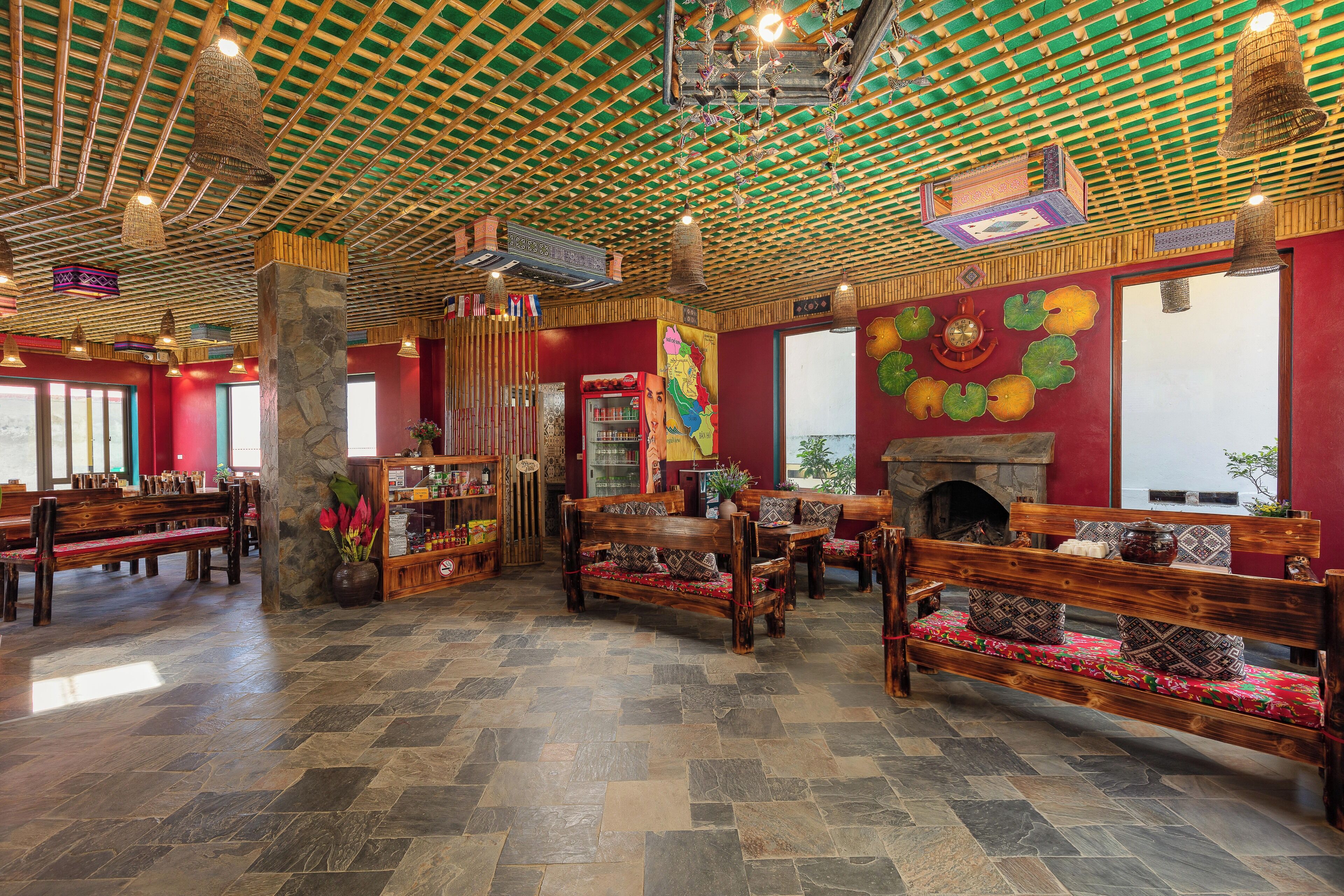 A spacious lobby with wooden benches, a stone pillar, and a colorful mural.