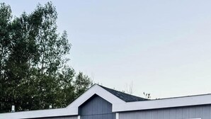 En etagers bygning med grå facade, hvide detaljer og nummer '619' på den fremadvendte væg.