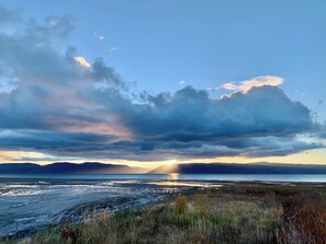 A coastal landscape with a body of water, distant mountains, and a cloudy sky. - Fantastic Cedar Lane Cottage, walking distance to beach and sports park (Garden City)