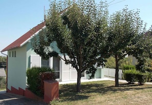 A single-story house with a red roof, a small front yard, and a tree in front. - Holiday home with large garden, garden pavilion and barbecue (Zalakaros)