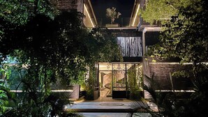 Un bâtiment moderne avec une façade en pierre, une entrée incurvée et un intérieur bien éclairé.