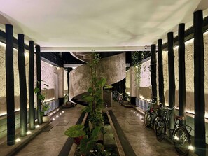 A modern interior with a central spiral staircase, potted plants, and bicycles. - Black House - Modern 3BR Villa with Private Pool (Tulum)
