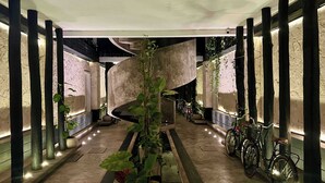 Un intérieur moderne avec un escalier en colimaçon, des plantes en pot et des vélos.