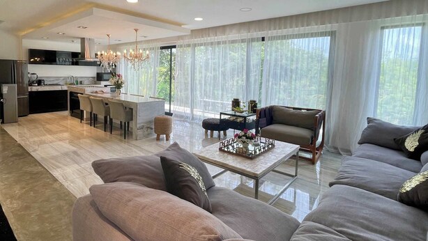 Un salon moderne avec un canapé, une table basse et un coin repas avec des chaises.