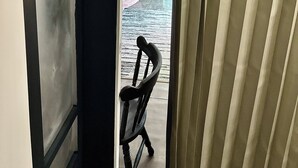A hallway leading to a room with a bed, a chair, and a small table. - Cozy lil 1 bedroom getaway (Rockport)