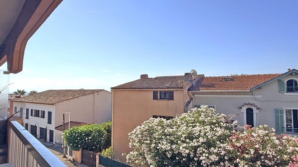 Zona residencial con casas, un balcón y cielo despejado.