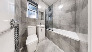 Ein modernes Badezimmer mit Toilette, Waschbecken und Dusche.