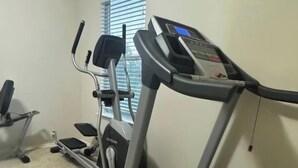 Una palestra in casa con tapis roulant, ellittica e cyclette.