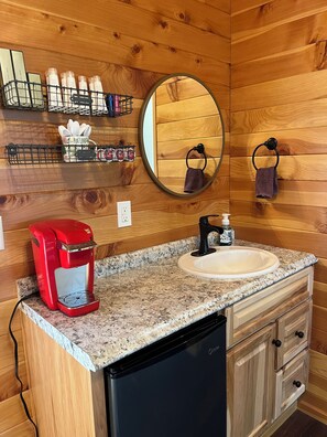 A wooden interior with a granite countertop, a red coffee maker, a sink, and a mirror. - Mountain View Treehouse in Sutherlin with full bath and AC, 5 minutes from I-5 (Sutherlin)