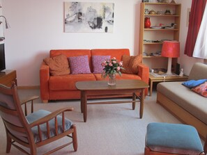 A living room with a sofa, a coffee table, a chair, and a bookshelf. - Quadra / Masé-Goldberg, (Flims Dorf), 1030 by Interhome (Flims)