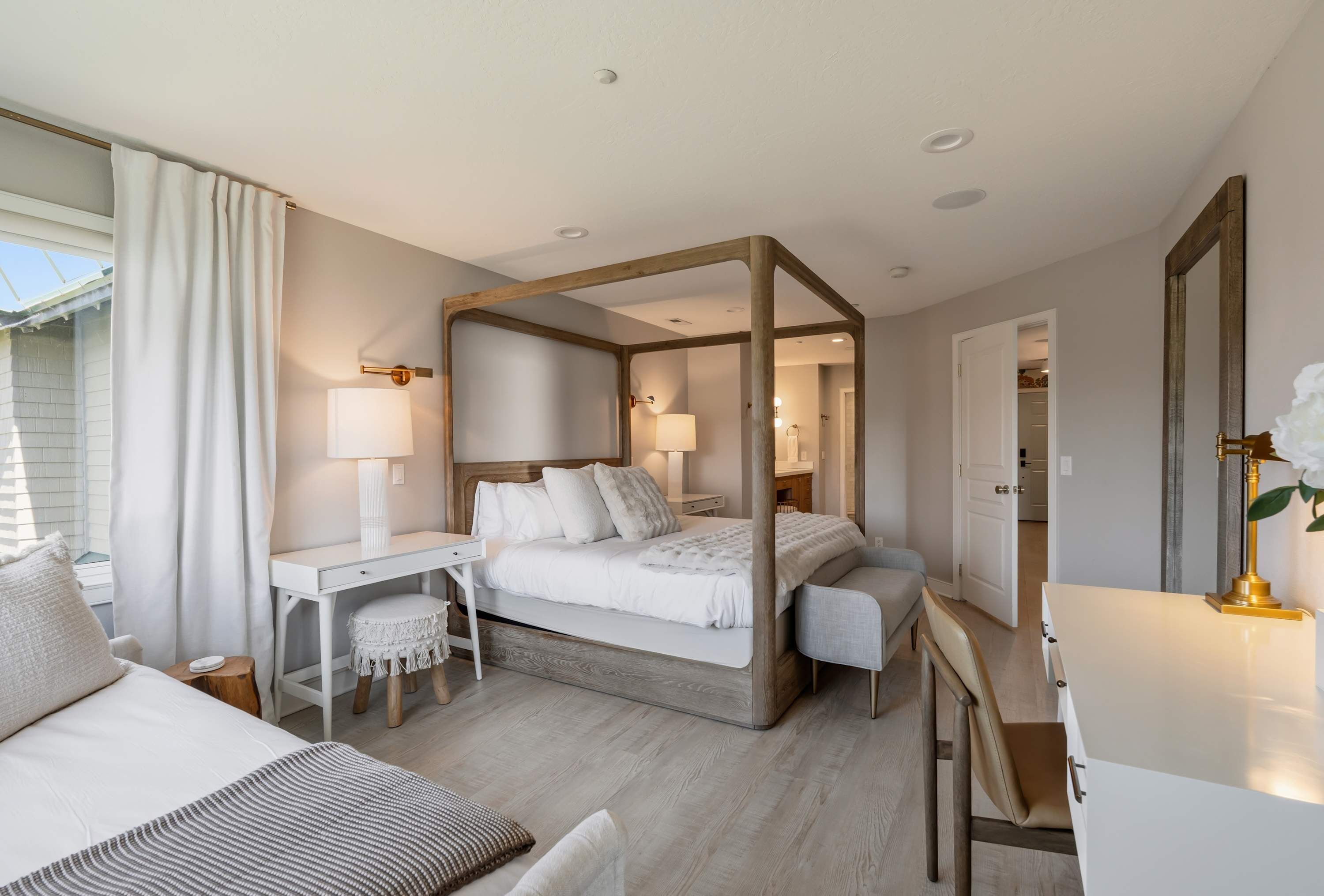 Une chambre à coucher avec un lit à baldaquin, un bureau, une chaise et une table de chevet.