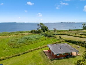 A house with a view of a large body of water, surrounded by green fields and a clear sky. - "Apsolon" - 100m from the sea by Interhome (Præstø)