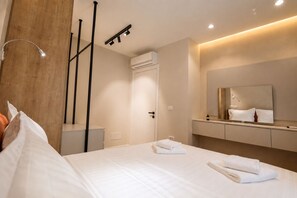 Une chambre d’hôtel comprenant un lit, une table de chevet, un miroir et un climatiseur fixé au mur.