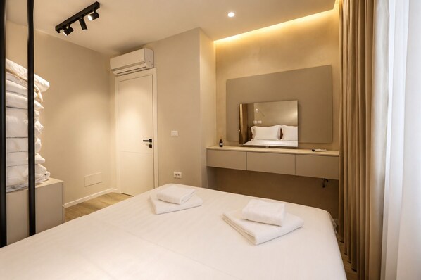 Une chambre d’hôtel équipée d’un lit, d’un miroir, d’une coiffeuse et d’un appareil de climatisation.
