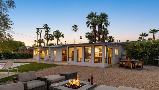A modern house with a patio, outdoor seating, and a fire pit. - Mountain Mirage | MCM 3BR | Private Pool & Spa | Bocce | Sleeps 6 (Palm Springs)