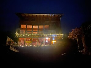 Um edifício de dois andares com varanda e luzes de festa.