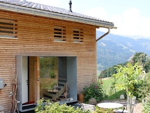 A modern house with a large glass door and a view of a mountainous landscape. - Ferienhaus Jukale, (Luzein), ferienhaus_jukale by Interhome (Luzein)