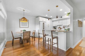 A modern kitchen with white cabinetry, a central island, and pendant lighting. - Charming 2BR/2BA Courtside Villa, near Equestrian Center and Tennis. (Seabrook Island)