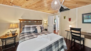 A bedroom with a bed, bedside table, lamp, and a desk with a chair. - Cozy High Country Retreat Near the Slopes (Sugar Mountain)