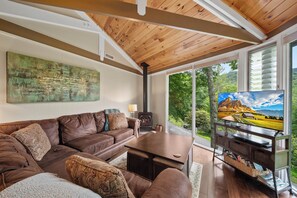 A modern living room with a brown leather sofa, a wooden coffee table, and a fireplace. - Cozy High Country Retreat Near the Slopes (Sugar Mountain)