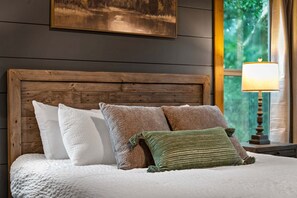 A bed with a wooden headboard, white and brown pillows, and a green throw pillow. - Talona Rising Sun - Mountain Views | Pet Friendly | Firepit | Game Room (Ellijay)